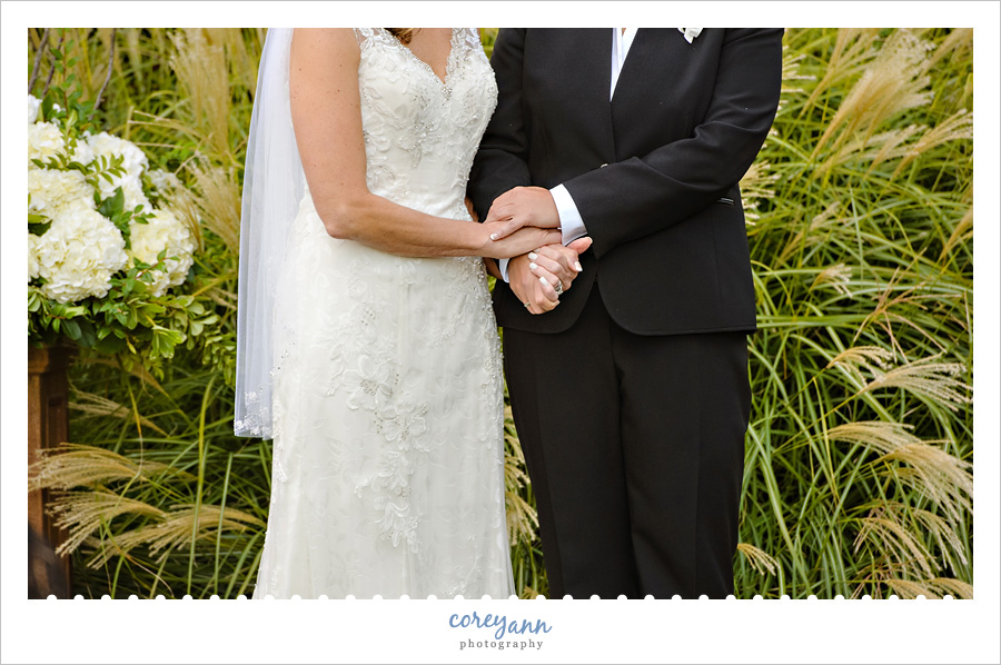 brides holding hands during ceremony with mary grigola