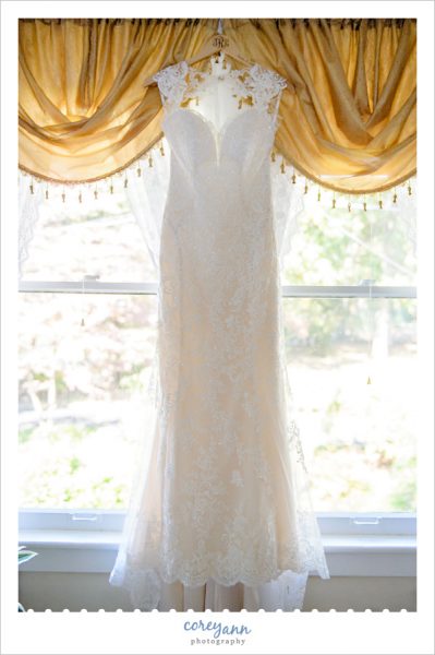 Ivory lace wedding dress hanging in window