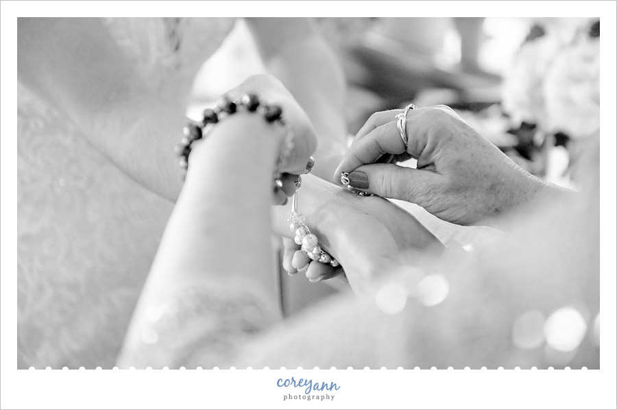 Bride's mother helping bride with bracelet