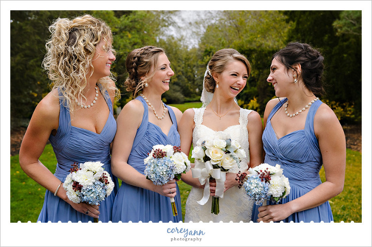 Bride laughing with bridesmaids in blue