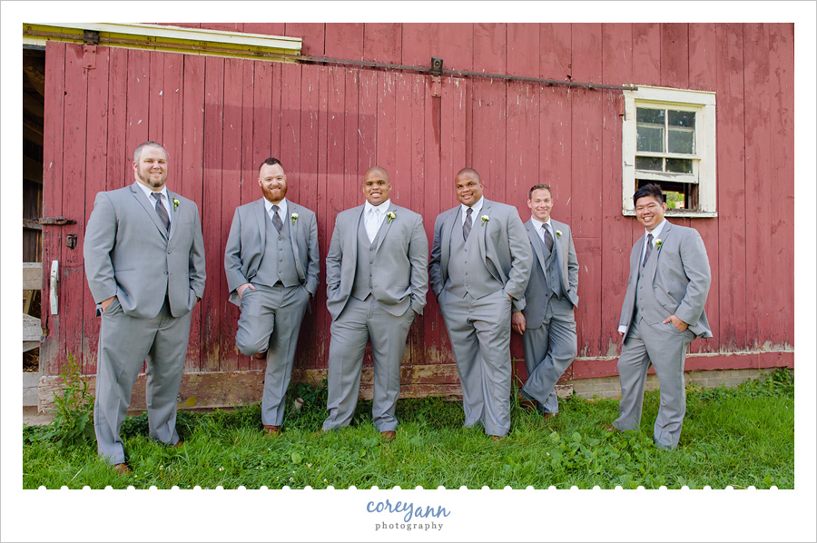 Groom and groomsman against red barn in Ohio