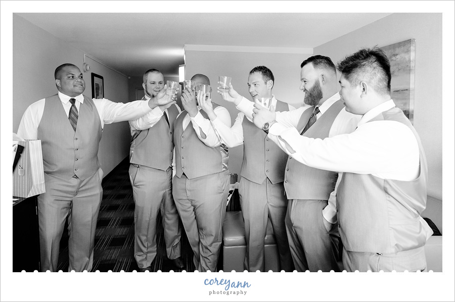 Groom and groomsman toasting before wedding