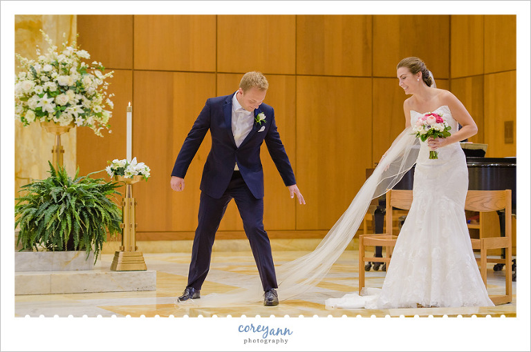 Groom stepping on bride's veil 