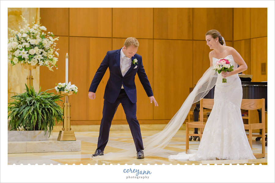 Groom stepping on bride's veil