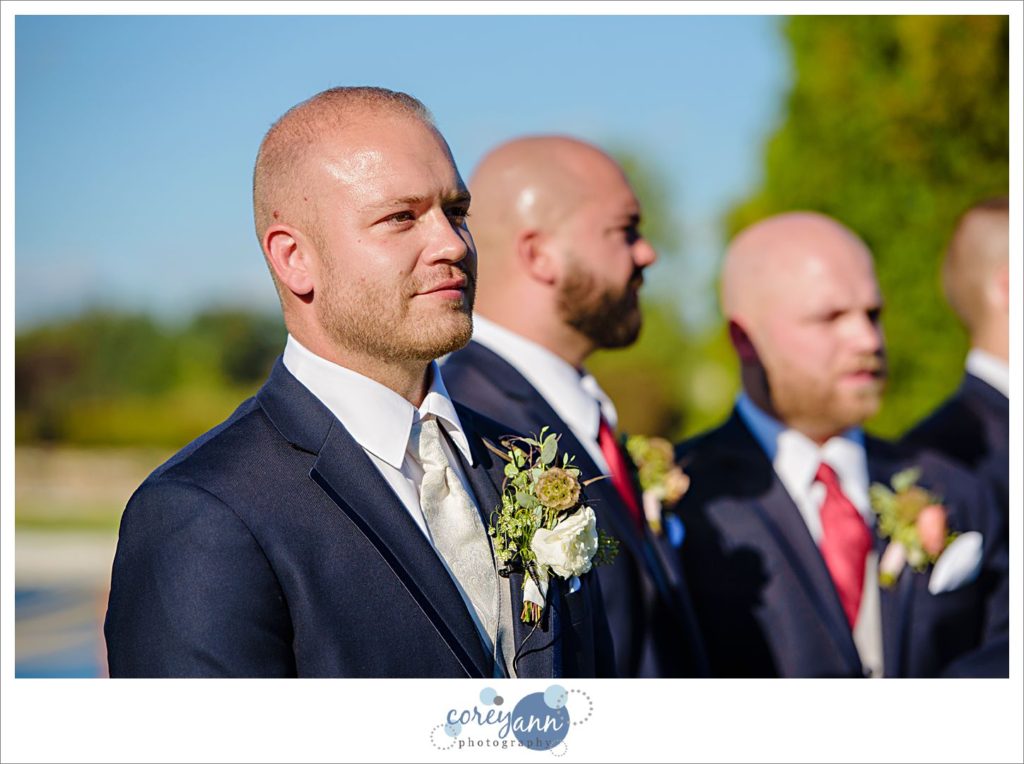 Groom watching bride walking down aisle