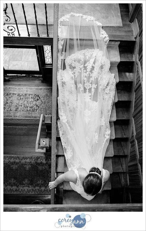 Bride walking down stairs at oneil house in Akron