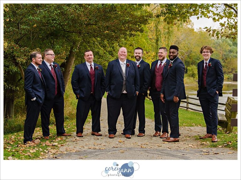 Groomsman in navy blue suits with red vest and tie