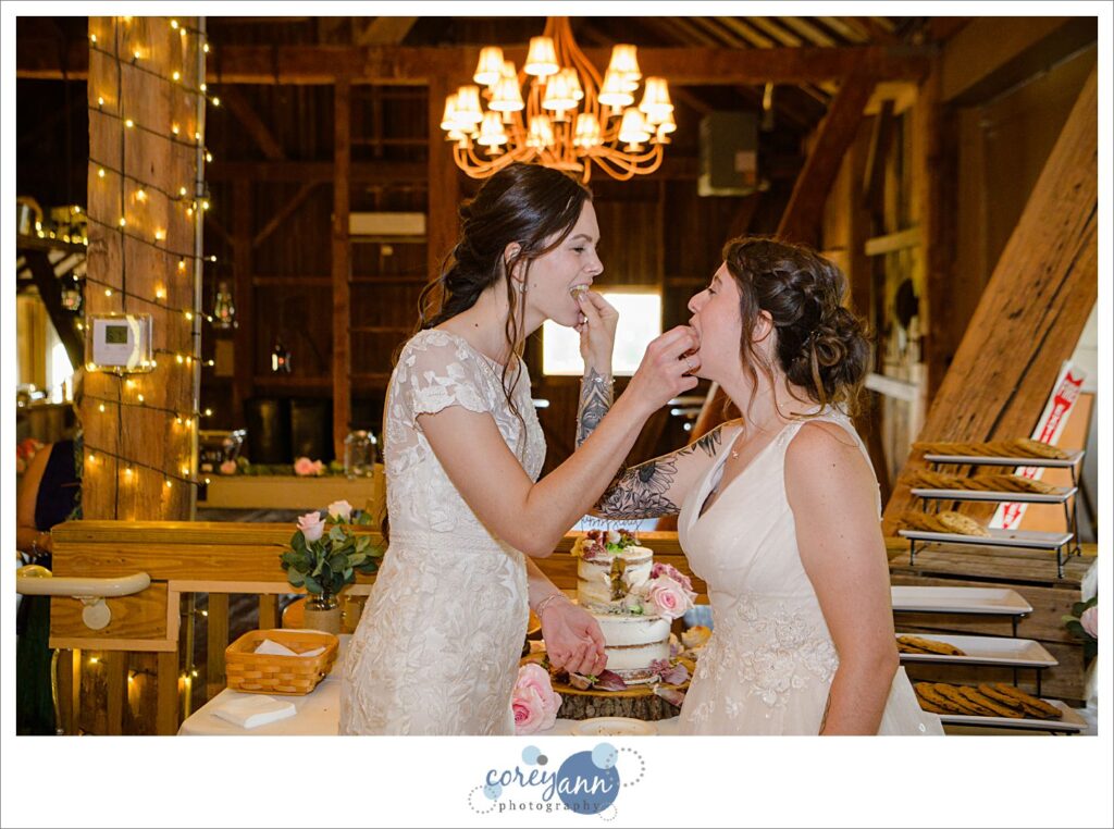 Brides eating cake at wedding reception at Brookside Farm