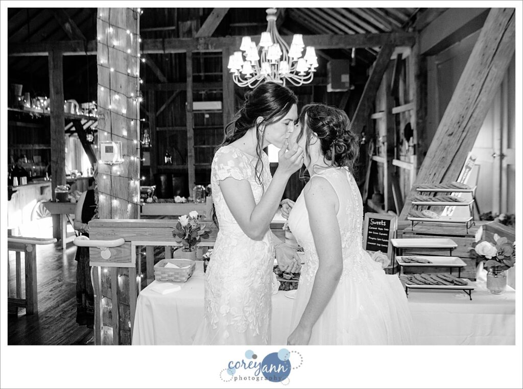 Brides eating cake at wedding reception at Brookside Farm