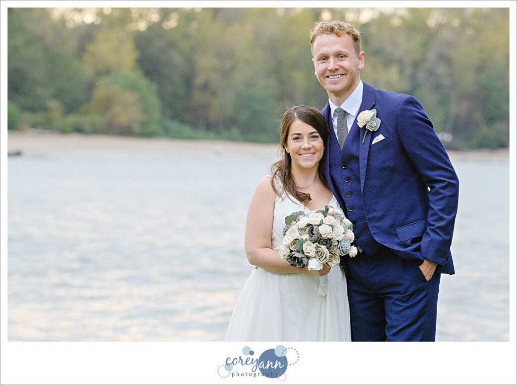 Man and woman in bridal attire in front of Lake Erie at sunset 