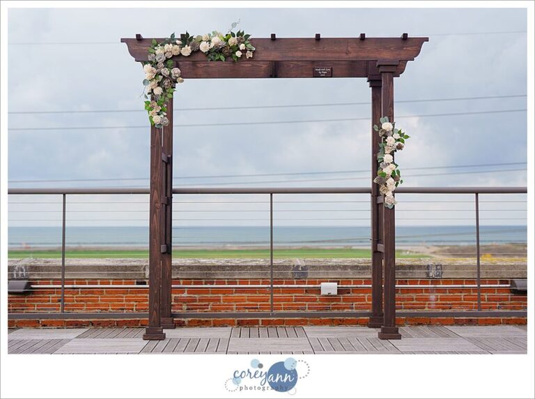 Dark wooden arch for ceremony altar decorated with sola wood flowers