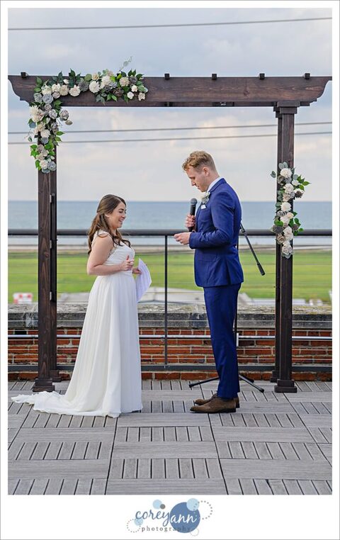 Man and woman in wedding attire during ceremony overlooking Lake Erie in Cleveland