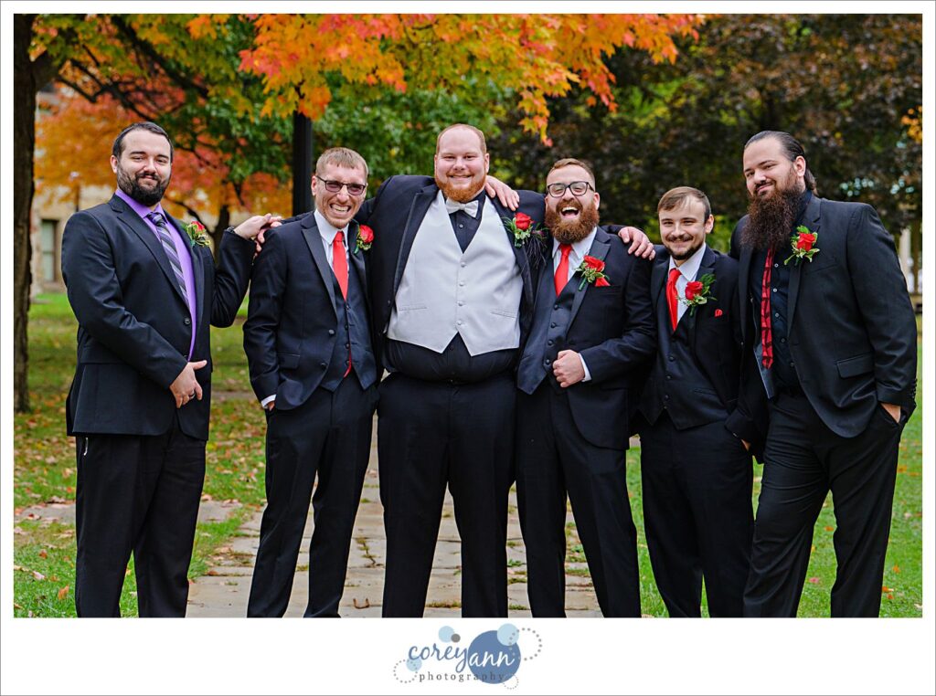 Groom and groomsman wearing black suits with red ties in Warren, Ohio