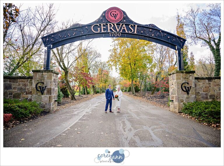 Bride and Groom posing beneath the Gervasi Vineyard Arch after their wedding ceremony.