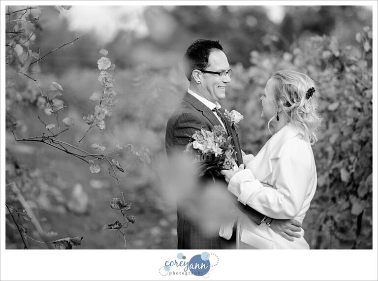 Bride and groom looking at each other in the vines at Gervasi Vineyard on their wedding day.
