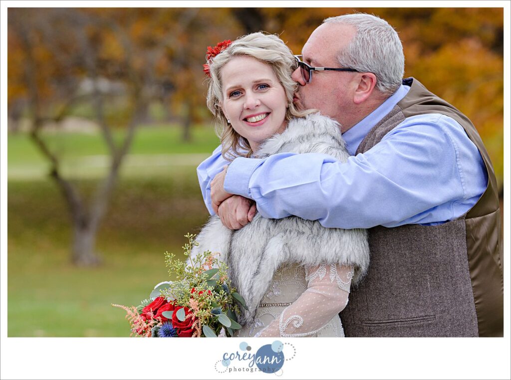 Groom kissing the cheek of his bride before wedding at Prestwick Country Club