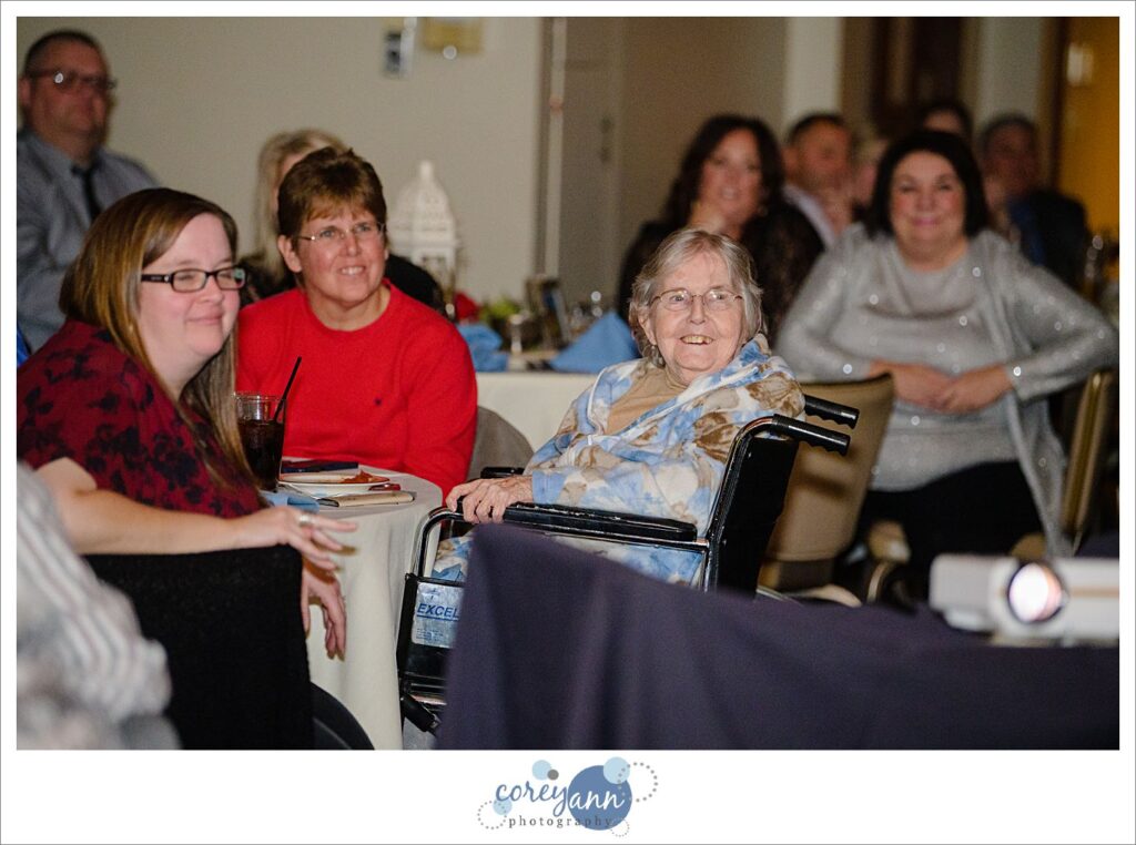 Guests watching video of wedding ceremony at wedding reception during covid pandemic