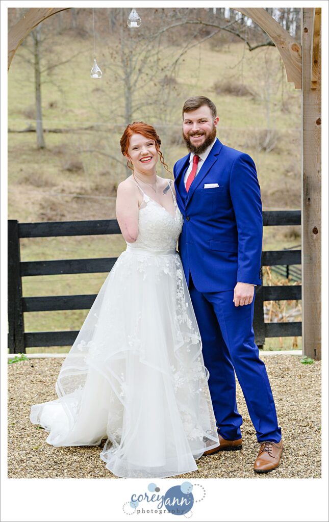 Bride and groom smiling at the camera outside at Rivercrest Farm.