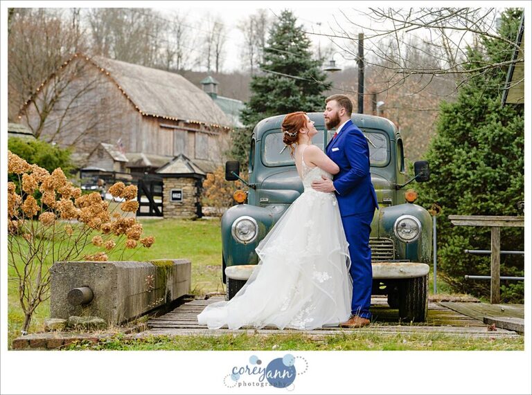 Bride and groom by antique truck at Rivercrest Farm.