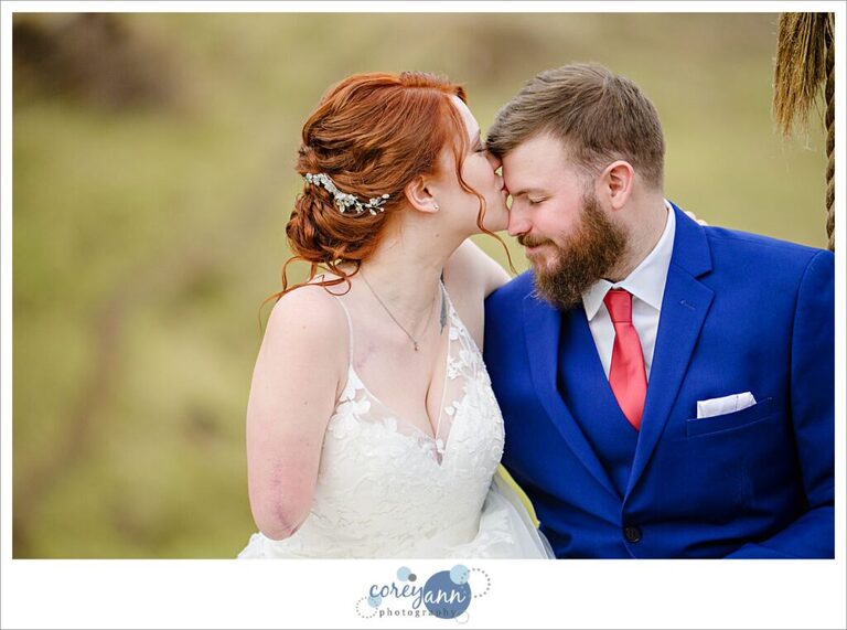 Bride kissing groom's forehead during portraits at Rivercrest Farm