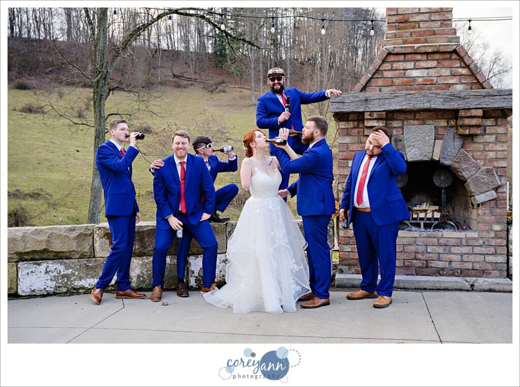 Groomsman and bride and groom chugging beers before winter wedding in Ohio