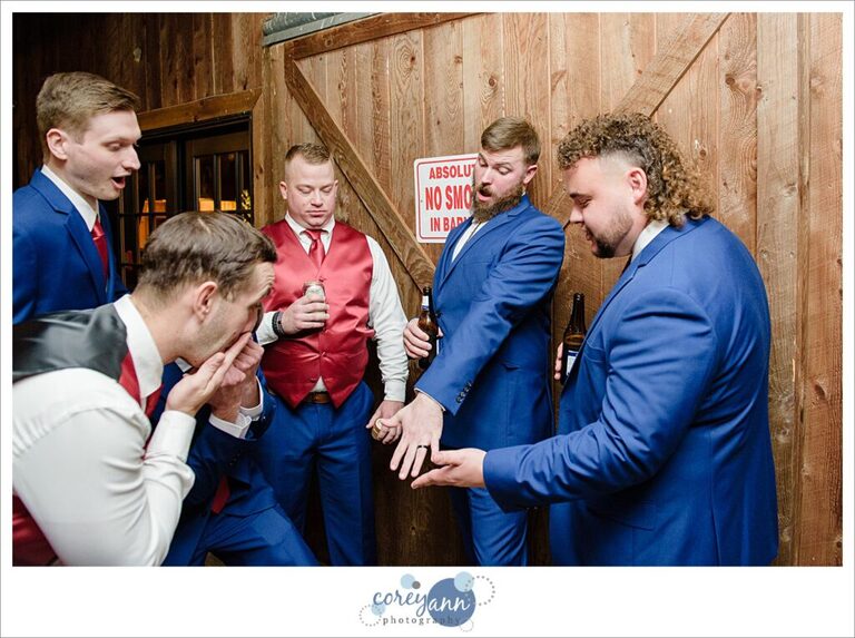 Groom showing off wedding ring to his groomsman after wedding ceremony