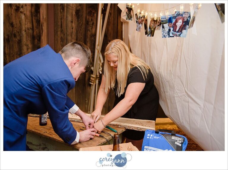 Guests burning wood for a guestbook at a wedding
