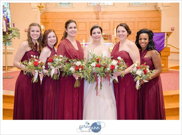 Bride and Bridesmaids in red holding festive bouquets in December