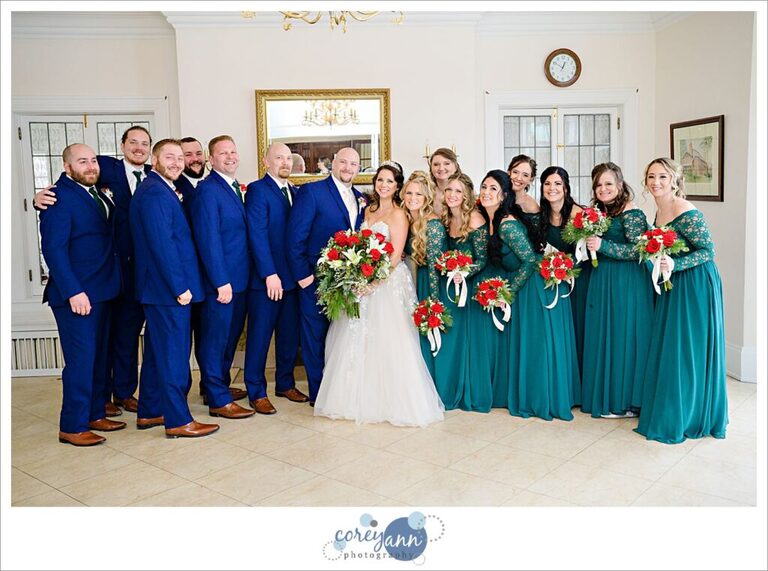 Bridal party wearing blue and green with christmas themed bouquets at Henn Mansion