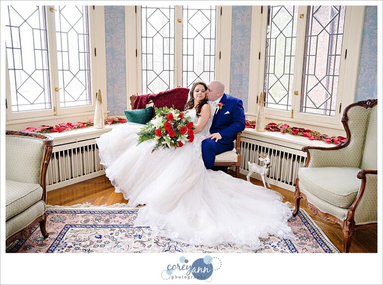 Bride and groom sitting on couch at Henn Mansion on their wedding day in Elyria Ohio