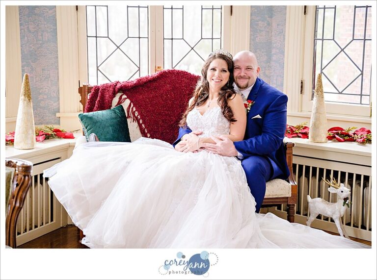 Bride and groom sitting on couch at Henn Mansion on their wedding day in Elyria Ohio