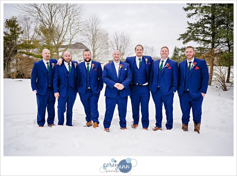 Groom and groomsman in blue suits in the snow at Inn Walden after wedding