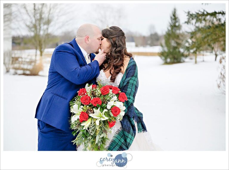 Groom kissing bride outside in the snow on their wedding day at Inn Walden