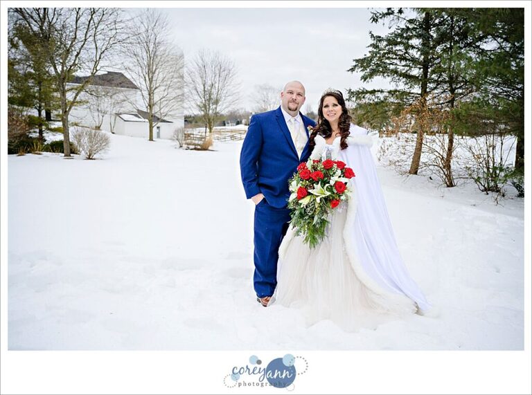 Bride and groom standing in the snow with the barn in the background at Inn Walden