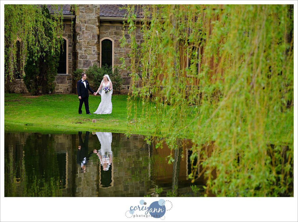 Bride and groom walking along pond near the villas at Gervasi Vineyard in Canton Ohio