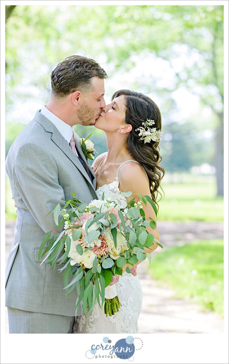 Bride and groom kissing before wedding reception at Pine View Acres