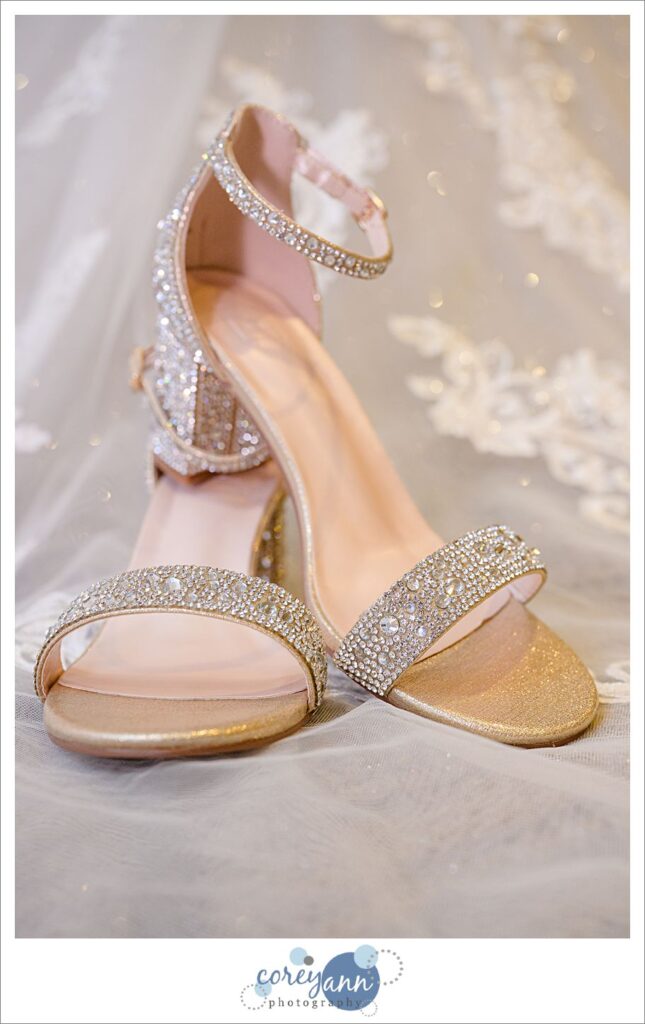 Strappy sparkly heels on the train of a wedding dress