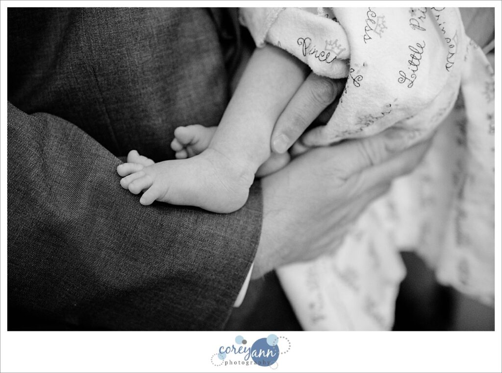 man holding a baby in black and white showing the baby's foot