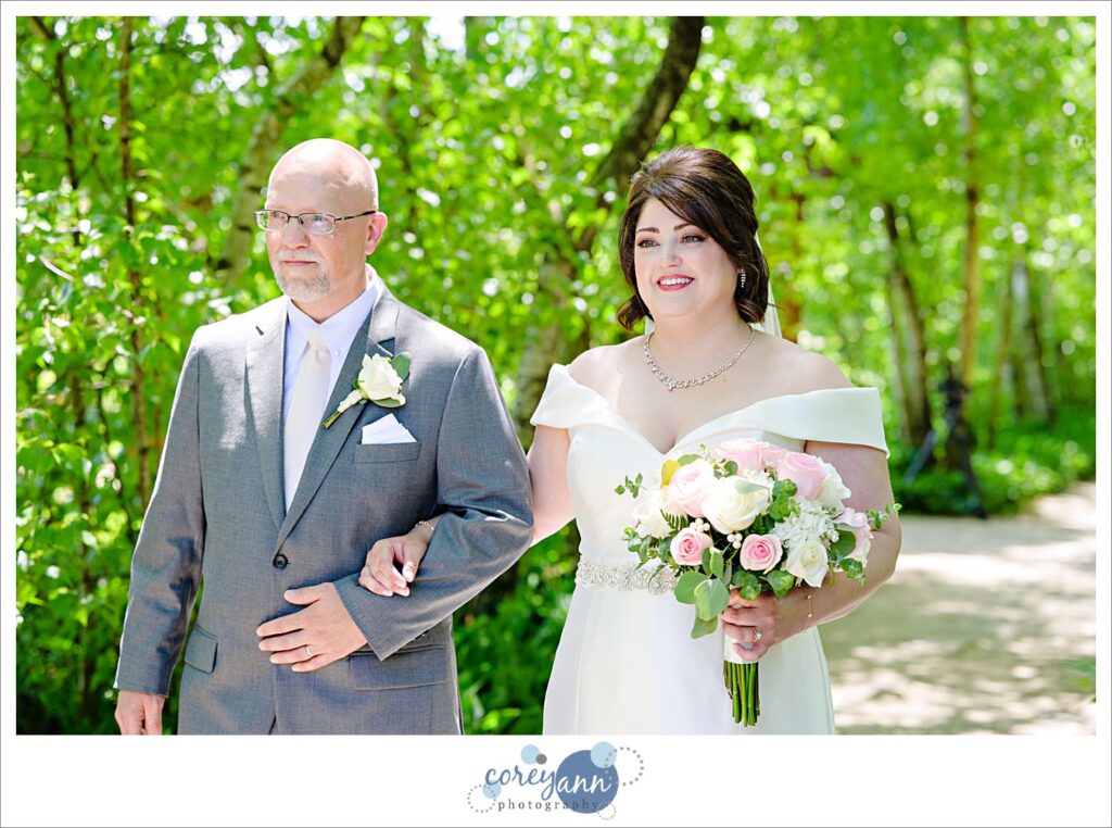Father and daughter walking down the birch tree allee aisle to wedding ceremony at Stan Hywet