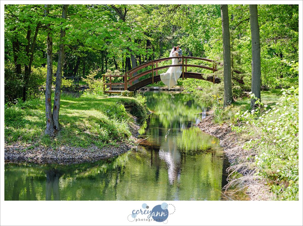 bride and groom on bridge over lagoons at stan hywet after their wedding