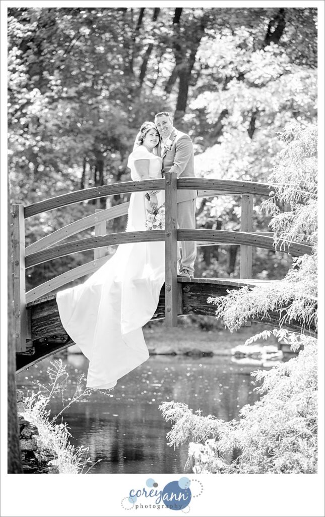bride and groom on bridge over lagoons at stan hywet after their wedding