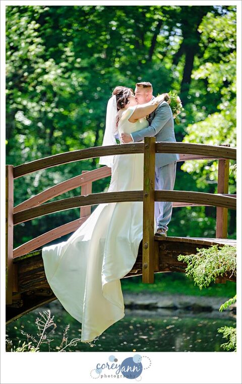 bride and groom on bridge over lagoons at stan hywet after their wedding