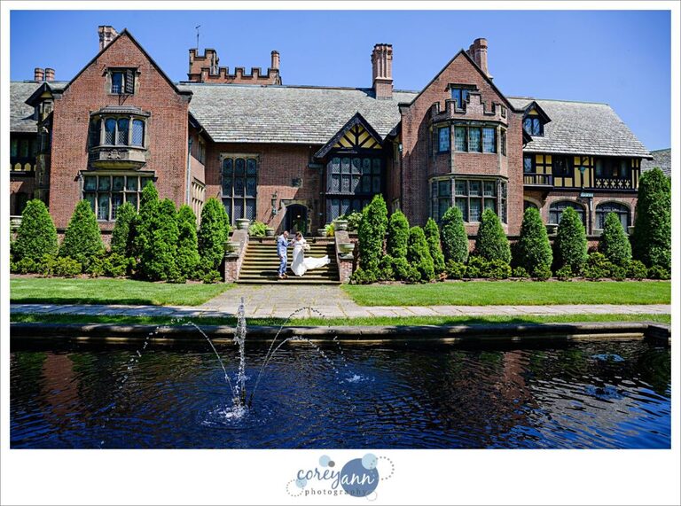 wedding couple walking down stairs of the manor house at Stan Hywet Hall and Gardens