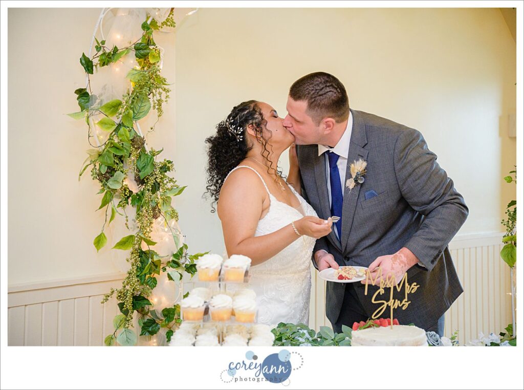 Bride and groom cutting their white wedding cake during their wedding reception at Springlake Party Center in Akron Ohio