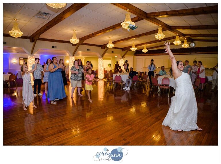 Bride tossing her bouquet to the single ladies on the dance floor during the wedding reception in Akron Ohio