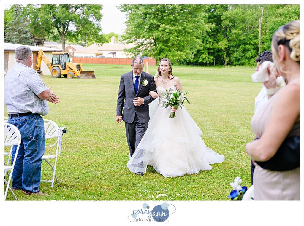 Bride walking down the aisle to her groom at Amy's Rustic Event Center in Valley City Ohio for a June wedding