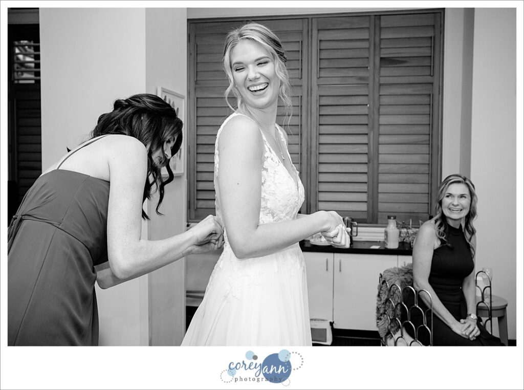 Bride laughing with her sister while getting dressed at Hyatt Regency Cleveland at The Arcade in Ohio