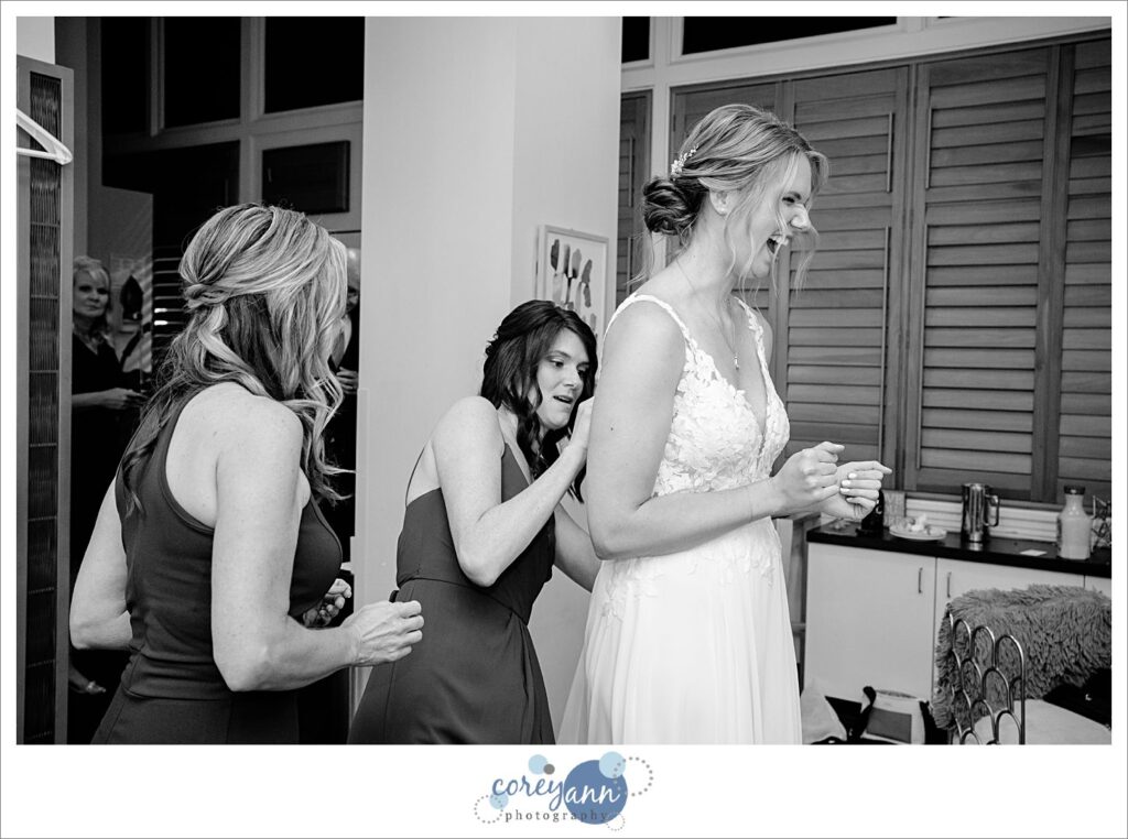 Bride laughing with her sister while getting dressed at Hyatt Regency Cleveland at The Arcade in Ohio