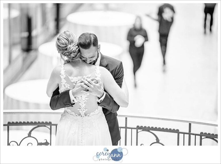 Bride and groom embrace after first look at Hyatt Regency Cleveland at The Arcade