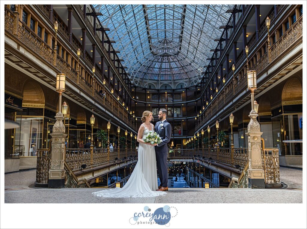 bride and groom standing inside the Hyatt Regency Cleveland at The Arcade before their wedding